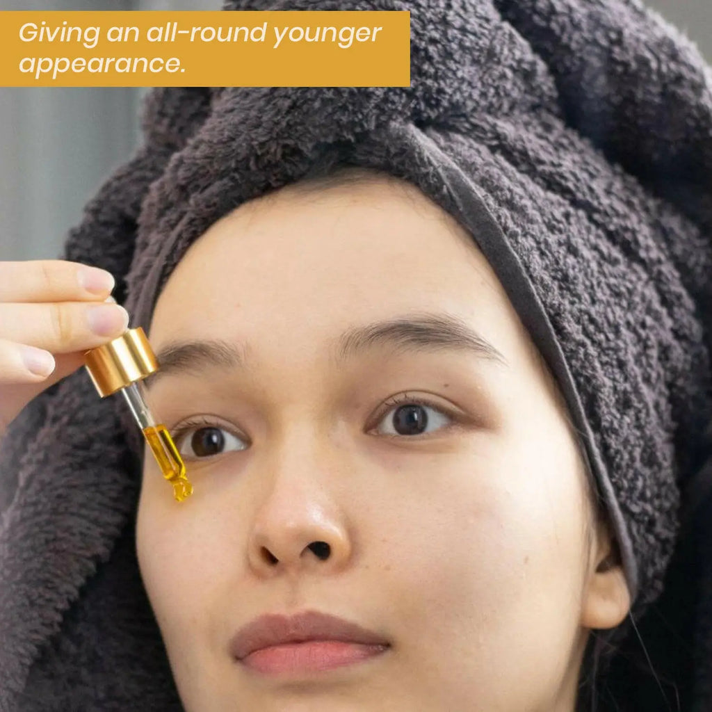 Ammuri Skincare 24k gold face serum being applied to enhance skin's youthfulness