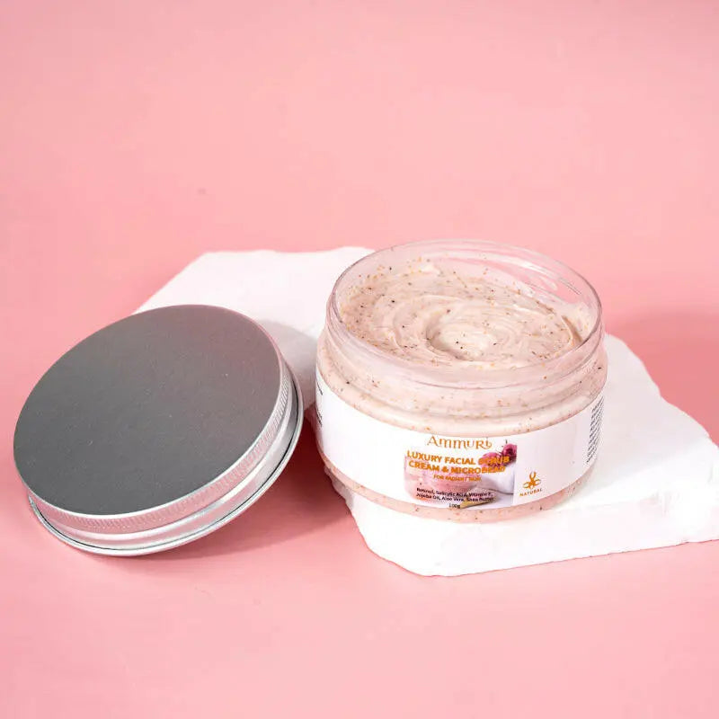 Ammuri Skincare Retinol Facial Scrub in a clear jar on a white stone background for deep exfoliation